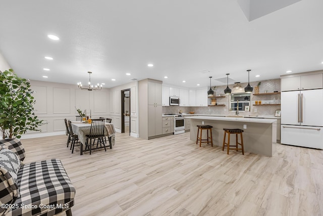 interior space featuring light wood-type flooring, sink, and an inviting chandelier