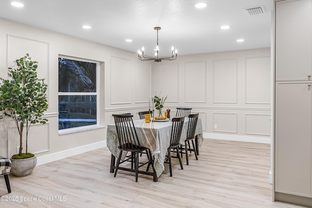 dining space featuring an inviting chandelier and light hardwood / wood-style floors