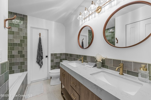 bathroom with vanity, toilet, tile walls, and tiled tub