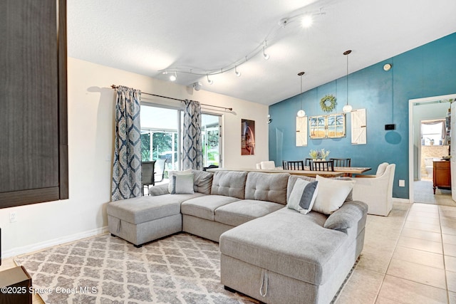 tiled living room featuring vaulted ceiling and rail lighting