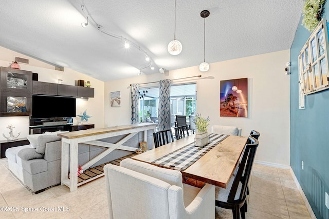 tiled dining room with rail lighting, vaulted ceiling, and a textured ceiling