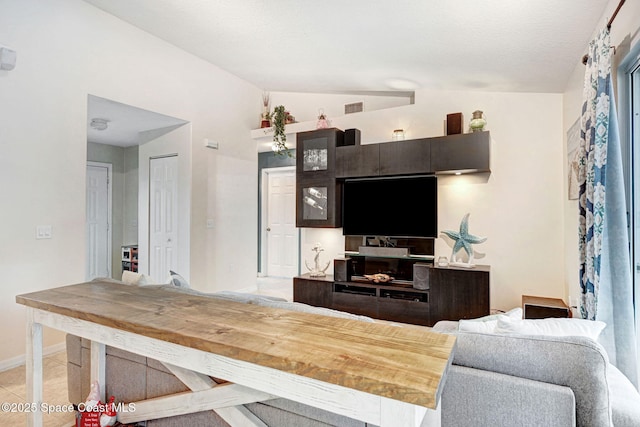 living room featuring lofted ceiling and light tile patterned floors