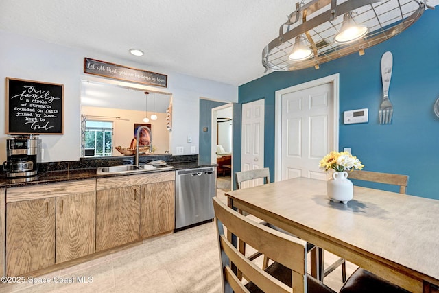 kitchen with sink, hanging light fixtures, dark stone countertops, light tile patterned floors, and stainless steel dishwasher