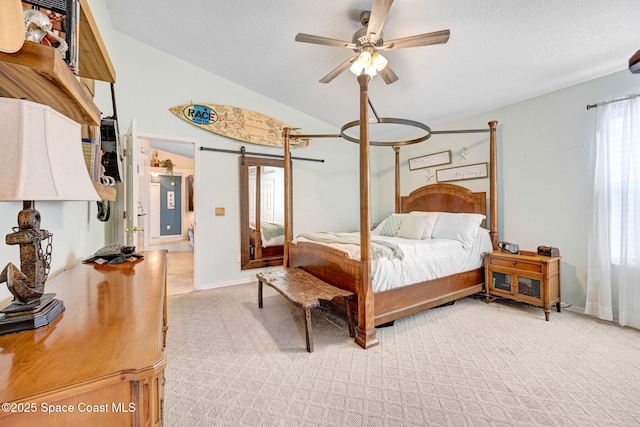 bedroom with lofted ceiling, light carpet, a textured ceiling, ceiling fan, and a barn door