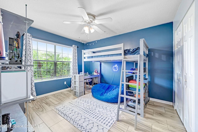 bedroom with ceiling fan and a textured ceiling