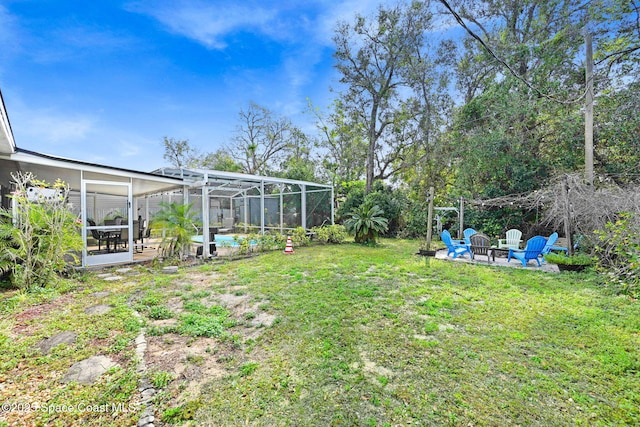 view of yard featuring a fire pit and a lanai