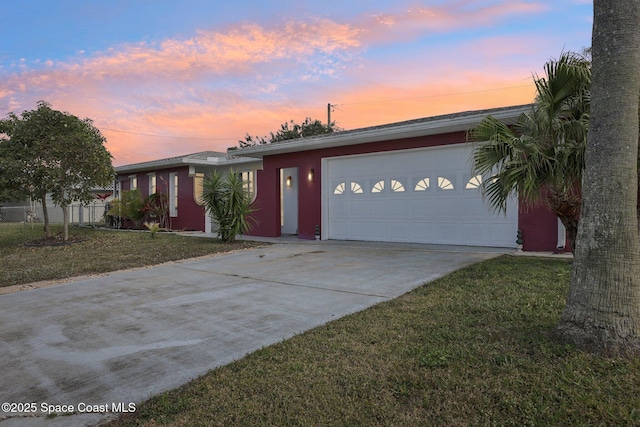 ranch-style home with a yard and a garage