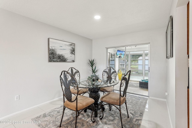 dining space with tile patterned flooring and a textured ceiling