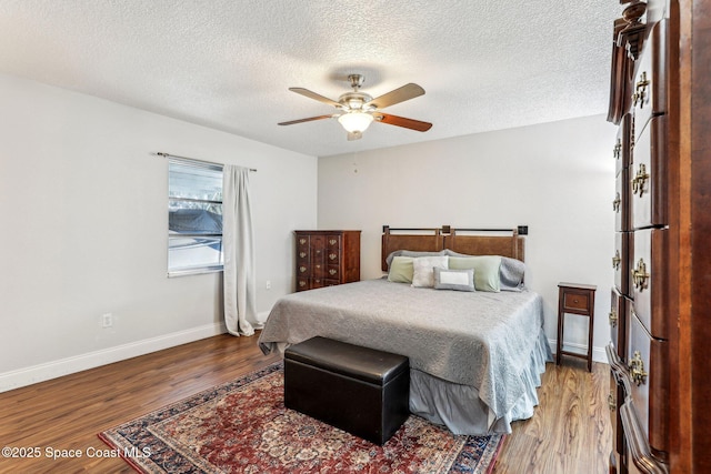 bedroom featuring wood-type flooring, a textured ceiling, and ceiling fan