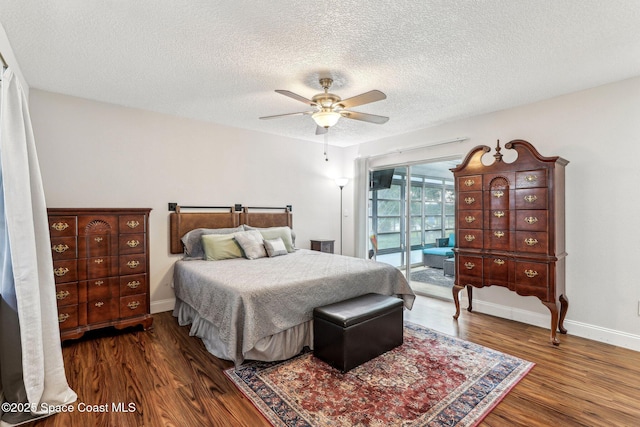 bedroom with access to exterior, a textured ceiling, dark wood-type flooring, and ceiling fan