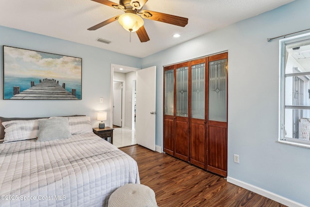 bedroom featuring dark wood-type flooring, ceiling fan, and a closet