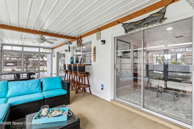 living room with ceiling fan, plenty of natural light, and concrete flooring