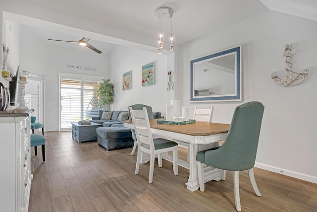 dining room featuring vaulted ceiling, ceiling fan, and light hardwood / wood-style flooring