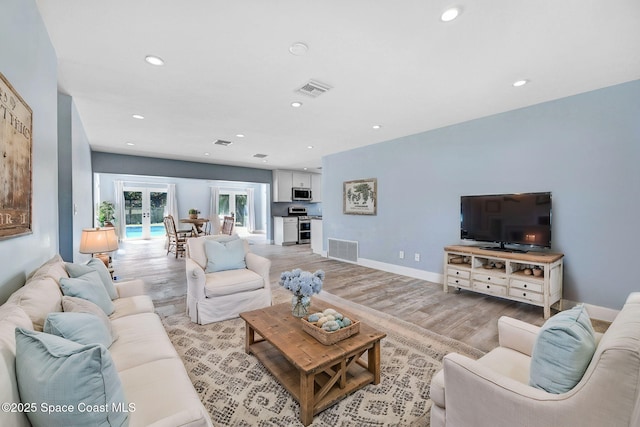 living room featuring light hardwood / wood-style floors and french doors