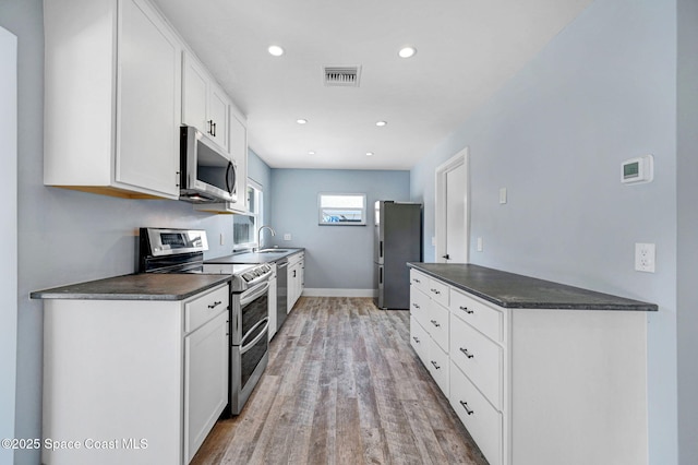 kitchen featuring white cabinetry, appliances with stainless steel finishes, sink, and light hardwood / wood-style floors