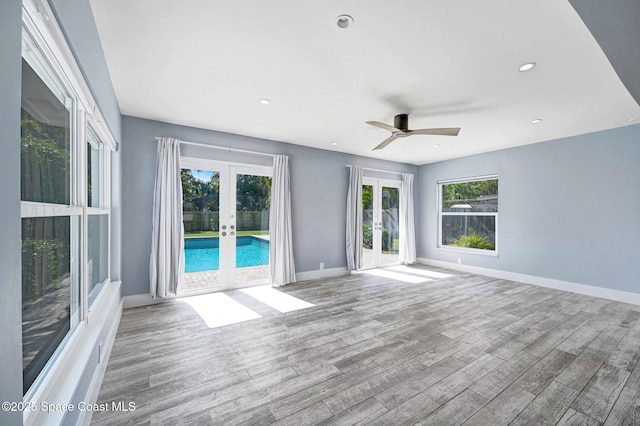 spare room with light hardwood / wood-style flooring, ceiling fan, and french doors