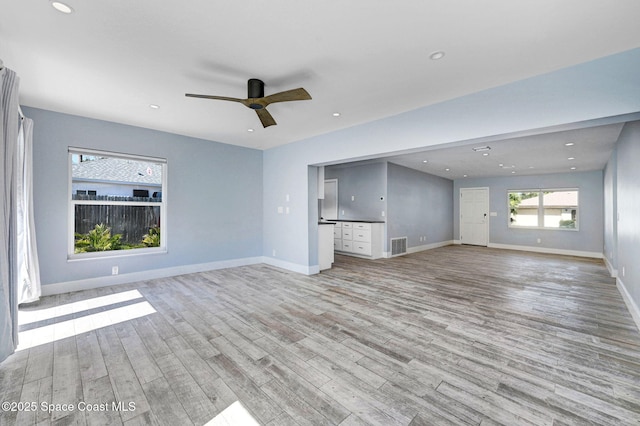 unfurnished living room with ceiling fan and light wood-type flooring