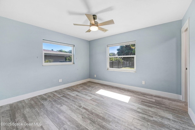 empty room with hardwood / wood-style flooring, a wealth of natural light, and ceiling fan