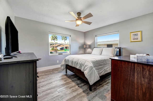 bedroom with light hardwood / wood-style flooring and ceiling fan