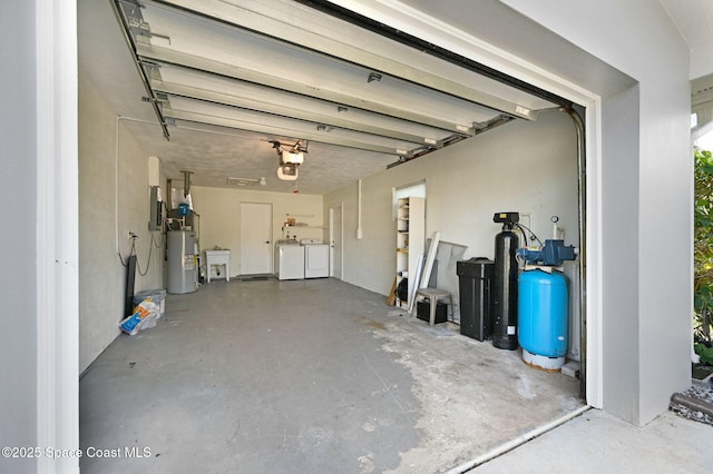 garage with separate washer and dryer, a garage door opener, electric panel, and electric water heater