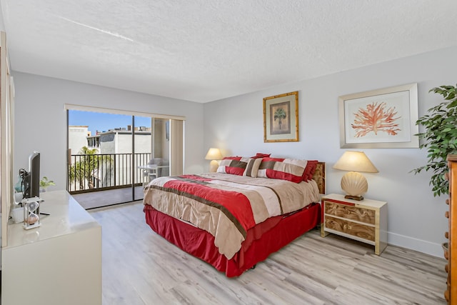 bedroom featuring access to outside, light hardwood / wood-style floors, and a textured ceiling