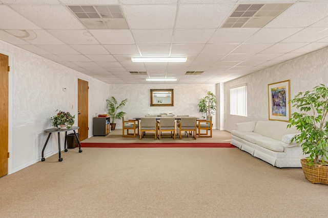 living room with a paneled ceiling and carpet floors