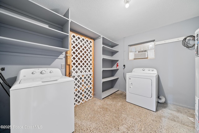 washroom featuring separate washer and dryer, an AC wall unit, and a textured ceiling