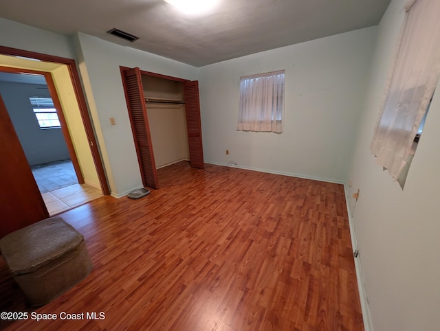 unfurnished bedroom with a closet and light hardwood / wood-style flooring