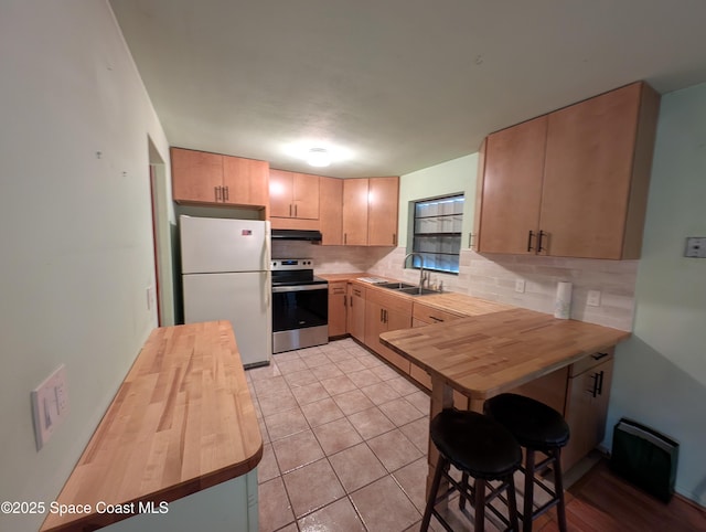 kitchen featuring wooden counters, white fridge, electric range, and light brown cabinetry