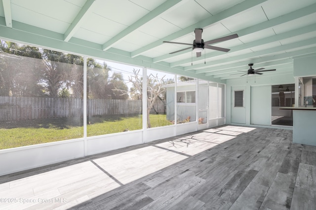 unfurnished sunroom featuring ceiling fan and beam ceiling