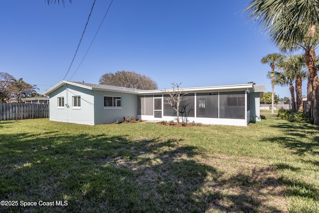 back of property featuring a yard and a sunroom