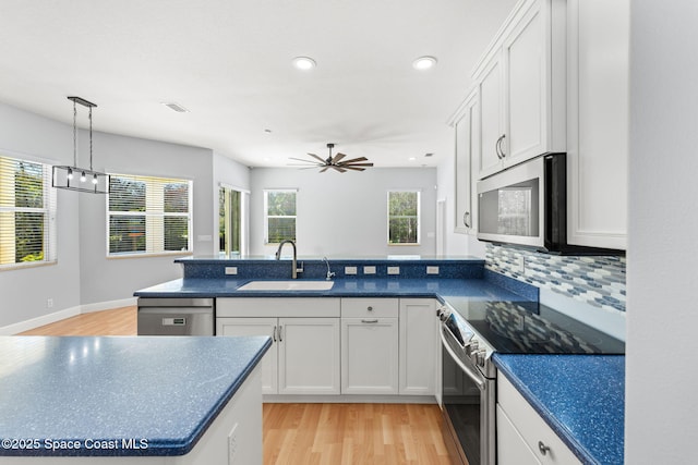 kitchen with sink, light hardwood / wood-style flooring, stainless steel appliances, and white cabinets