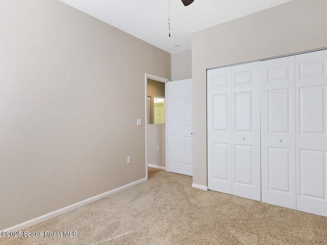 unfurnished bedroom featuring light colored carpet, ceiling fan, and a closet