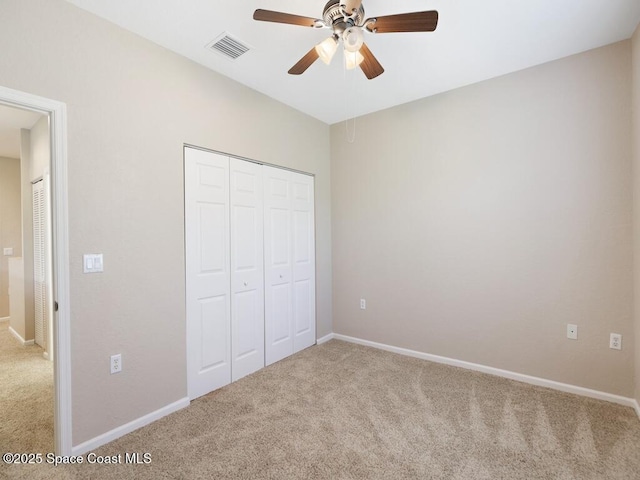 unfurnished bedroom with ceiling fan, carpet floors, and a closet