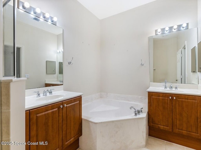 bathroom featuring vanity, tile patterned flooring, and a washtub