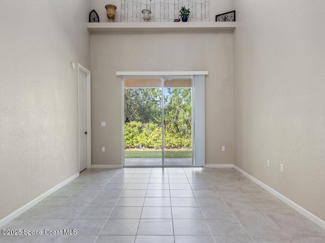 tiled empty room with a high ceiling