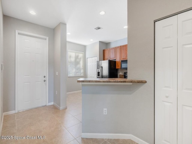 kitchen with black appliances and light tile patterned flooring