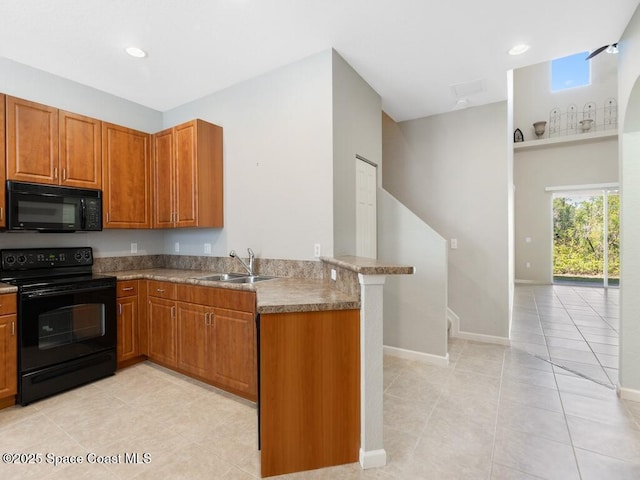 kitchen featuring sink, kitchen peninsula, light tile patterned floors, and black appliances