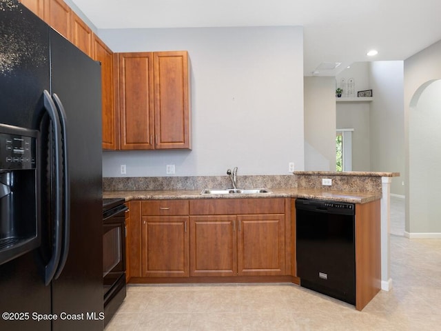 kitchen with sink, light tile patterned floors, black appliances, light stone countertops, and kitchen peninsula