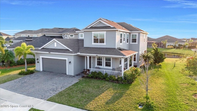 view of front facade featuring a garage, a front yard, and covered porch