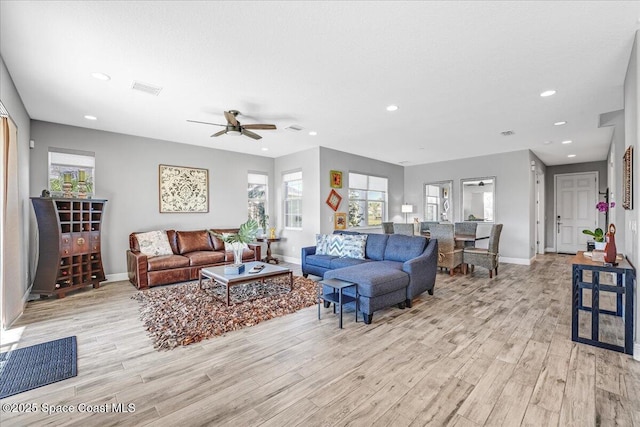 living room with a textured ceiling, light hardwood / wood-style floors, and ceiling fan