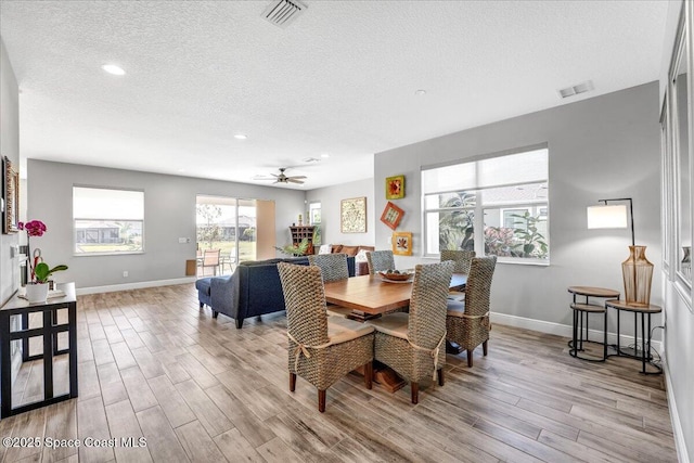 dining space featuring ceiling fan, a textured ceiling, and light wood-type flooring