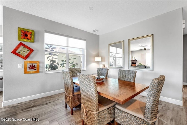 dining area with light hardwood / wood-style flooring and a textured ceiling