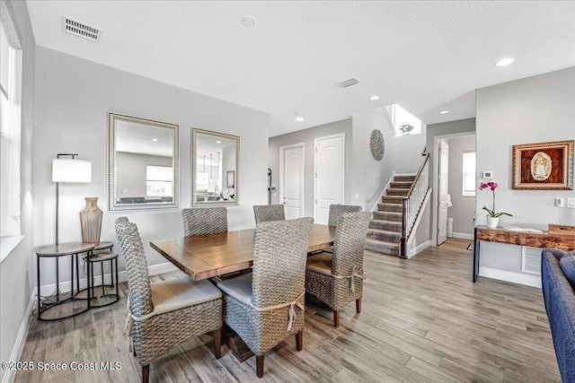 dining room with a textured ceiling and light hardwood / wood-style floors