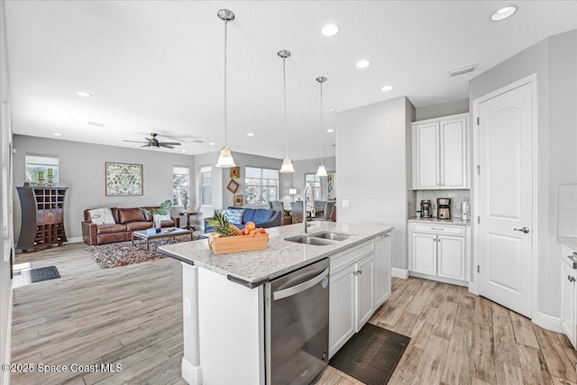 kitchen featuring stainless steel dishwasher, decorative light fixtures, sink, and white cabinets