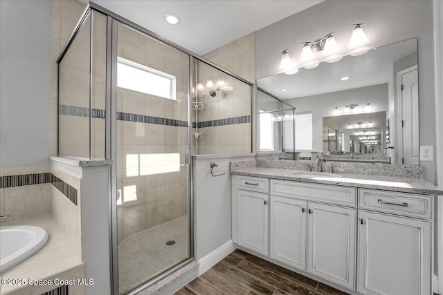 bathroom with vanity, hardwood / wood-style floors, and plus walk in shower