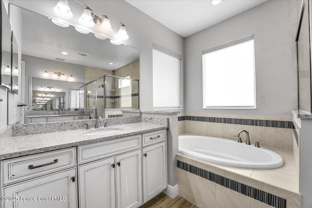 bathroom with vanity and independent shower and bath