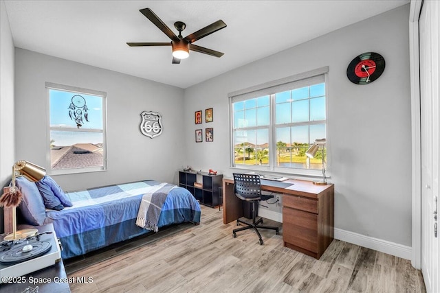 bedroom featuring multiple windows, ceiling fan, and light wood-type flooring