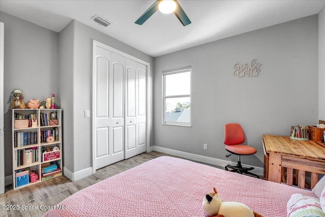 bedroom with a closet, ceiling fan, and light hardwood / wood-style flooring