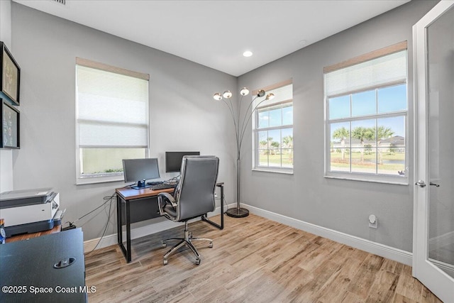 home office with light hardwood / wood-style floors